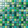 Mano que pinta el mosaico de cristal del color verde